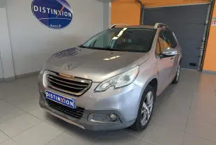 Peugeot 2008 gris artense en 3/4 avant droit dans un showroom avec logo Distinxion en arrière-plan.