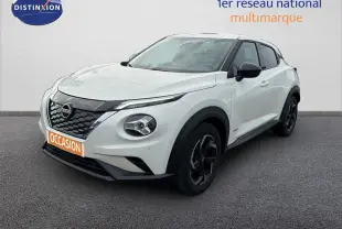 Nissan Juke blanc lunaire métal en 3/4 avant droit, avec jantes noires et calandre noire distinctive.