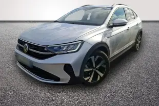 Volkswagen Taigo gris clair vu en 3/4 avant droit, avec jantes noires et phares LED distinctifs.