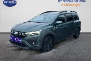 Dacia Jogger 2025 vert cèdre métal en 3/4 avant droit avec toit noir et jantes noires distinctives.