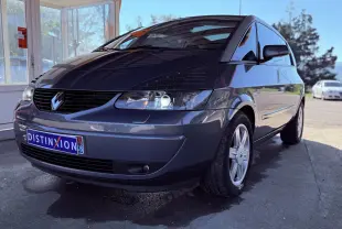 Renault Avantime gris en 3/4 avant droit, mettant en valeur sa silhouette unique et ses phares allumés.