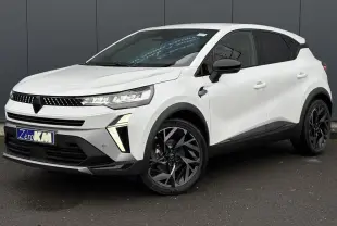 Renault Captur blanc nacré en 3/4 avant droit, avec jantes noires et détails noirs contrastants.