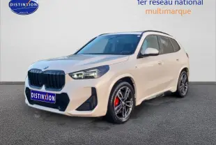 BMW X1 blanc minéral en 3/4 avant droit avec jantes alliage bicolores et étriers de frein rouges visibles
