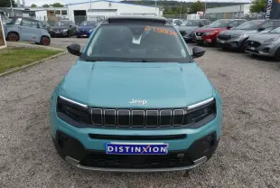Vue avant d'un Jeep Avenger bleu métallisé 2024 avec calandre noire et plaque Distinxion sur parking.