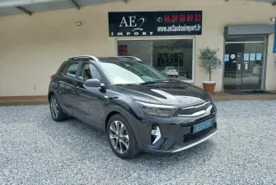 KIA STONIC noir 2025 en 3/4 avant droit, avec jantes alliage et toit ouvrant visible, stationné devant un garage.