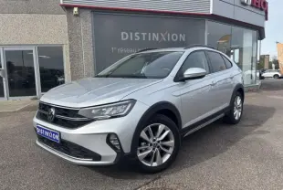 Volkswagen Taigo 2025 en Reflet d'Argent métallisée, vue 3/4 avant mettant en valeur ses jantes alliage et barres de toit noires.