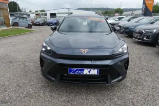 Vue avant d'un CUPRA Formentor gris magnétique avec logo cuivré et calandre noire sur un parking extérieur.