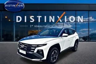 Hyundai Tucson blanc en 3/4 avant droit, avec calandre noire distinctive et jantes alliage 17 pouces.