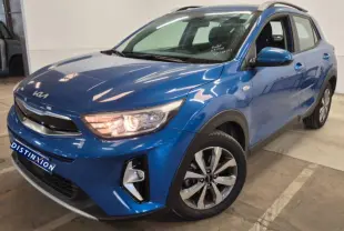 KIA Stonic bleu 2024 en 3/4 avant droit, avec phares allumés et jantes alliage distinctives.
