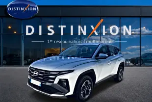Hyundai Tucson blanc en 3/4 avant droit, avec calandre noire distinctive et jantes alliage 17 pouces.