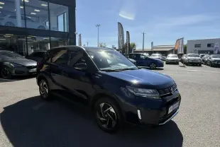 Suzuki Vitara 2025 bleu foncé métal en 3/4 avant droit, avec jantes alliage et badge Allgrip visible sur l'aile.