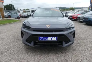 Vue frontale d'un CUPRA Formentor gris Graphène avec logo cuivre et calandre noire, stationné en extérieur.