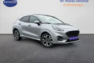Ford Puma 2024 gris Solar métallisé en vue 3/4 avant droit avec jantes alu et calandre noire distinctive.