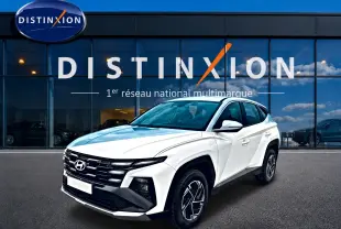 Hyundai Tucson blanc 2026 en 3/4 avant droit, avec calandre noire et jantes alliage 17 pouces visibles.