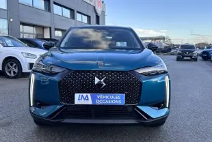 Vue avant d'une DS3 1.2 Hybride bleu avec calandre noire à motif losange et feux LED verticaux allumés.
