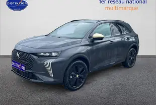DS7 gris titane en 3/4 avant droit, avec calandre distinctive et jantes noires brillantes.