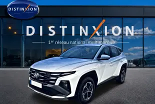 Hyundai Tucson blanc vu en 3/4 avant droit, avec calandre noire et jantes alliage 17 pouces distinctives.