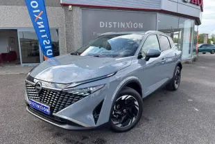 Nissan Qashqai e-POWER gris Argile en 3/4 avant droit, avec calandre distinctive et jantes noires brillantes.