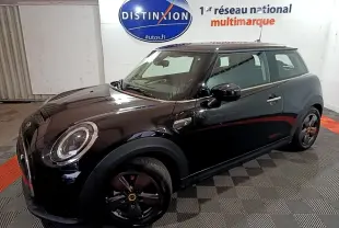 Vue 3/4 avant droite d'une MINI Cooper SE Essential noire avec jantes noires et phares ronds LED.