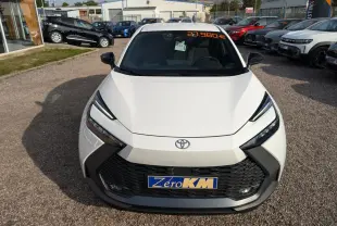 Vue avant d'une Toyota C-HR 2024 blanche avec calandre noire et phares LED anguleux en concession.