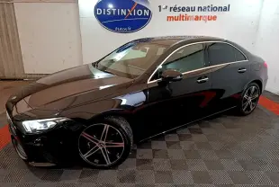 Mercedes Classe A Berline noire vue en 3/4 avant droit, avec jantes alliage et feux LED allumés dans un showroom.