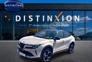 Vue 3/4 avant droite d'une Alfa Romeo Junior 1.2 hybride ivoire et noir, avec jantes alliage et toit noir brillant.