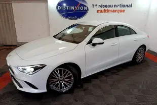 Mercedes Classe CLA 200 d Business Line blanc vue 3/4 avant droit, phares allumés et jantes alliage multibranches.