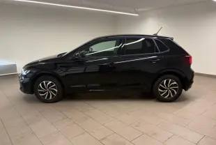 Vue de profil côté gauche d'une Volkswagen Polo noire intense 2025 dans un intérieur neutre, avec jantes alliage 15 pouces.