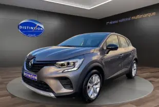 Renault Captur TCE 90 Équilibre gris Cassiopée en 3/4 avant droit, avec jantes argentées et calandre noire distinctive.