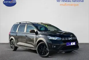 Dacia Jogger noir nacré métallisé en 3/4 avant droit avec barres de toit et jantes alu noires.