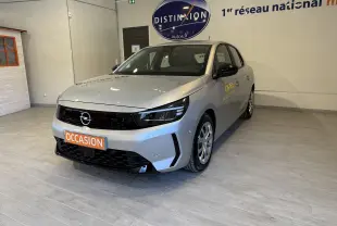 Opel Corsa gris 2024 en 3/4 avant droit, avec marquage jaune Opel sur la porte et plaque occasion orange.