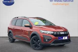 Dacia Jogger brun Terracota métallisé en 3/4 avant droit avec jantes noires et barres de toit visibles.