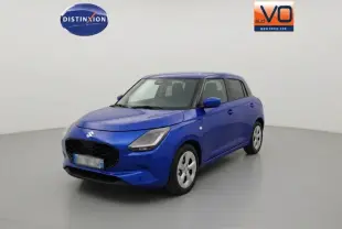 Suzuki Swift 1.2 Hybrid bleu en 3/4 avant droit, avec jantes alliage 16 pouces et phares modernes.