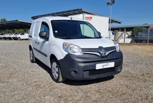 Vue 3/4 avant d’un Renault Kangoo blanc 2021 avec pare-chocs noir mat et calandre marquée du logo Renault.
