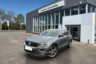 Volkswagen T-Roc gris Indium métal en 3/4 avant droit, avec jantes alliage et calandre R-Line visible.