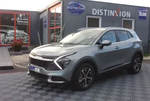 KIA Sportage gris perle en 3/4 avant droit, avec calandre distinctive et feux LED en forme de flèche.