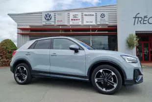 Audi Q2 35 TFSI 2023 gris flèche vue de profil côté gauche avec jantes sport 18'' et finition S line.