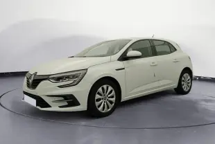 Renault Mégane IV Société blanche vue en 3/4 avant droit, stationnée devant un garage avec panneaux de service.