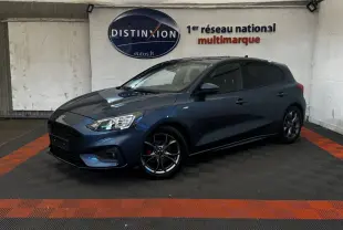 Ford Focus 5 portes bleu en 3/4 avant droit, jantes alliage noires et calandre noire distinctive St-Line.