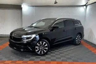 Renault Espace Techno 7PL E-Tech hybride noir, vue 3/4 avant droit avec rails de toit chromés et jantes stylées.