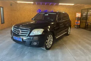 Mercedes GLK noir vue 3/4 avant droit dans un garage avec calandre chromée et jantes alliage.