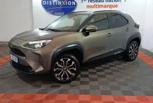 Toyota Yaris Cross gris foncé vue 3/4 avant droit, avec jantes alliage et phares LED allumés.