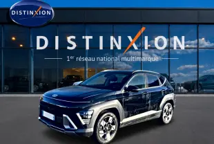 Hyundai Kona 2025 noir en 3/4 avant droit, avec jantes alliage et barres de toit visibles devant showroom Distinxion.