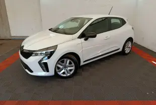 Renault Clio blanche vue 3/4 avant droit en intérieur, avec phares LED et rétroviseurs noirs contrastants.