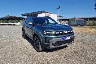 Dacia Duster 1.8 Hybrid 155 Extreme vert cèdre vu en 3/4 avant droit sur un sol gravillonné, avec rétroviseurs bronze.
