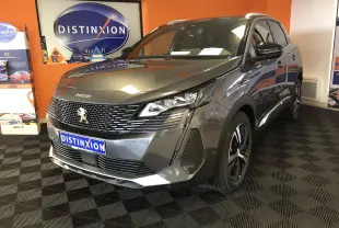 Peugeot 3008 1.2i 130 GT gris platinium avec toit noir, vue 3/4 avant droit en intérieur showroom.
