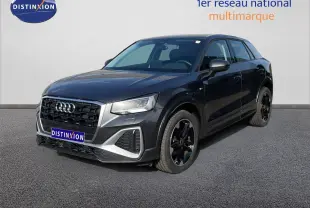 Audi Q2 gris Manhattan métal en 3/4 avant droit, avec calandre noire et jantes noires distinctives.