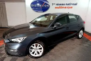 Vue 3/4 avant droit d'une SEAT Leon gris clair 2023 avec jantes alliage et phares LED ellipsoïdaux.