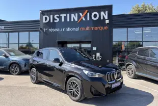 BMW X1 noir saphir vue 3/4 avant droit, avec calandre chromée et jantes alliage 18 pouces bicolores.