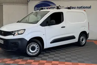 Vue 3/4 avant droit d'un utilitaire Peugeot Partner blanc avec barres de toit et jantes acier grises.